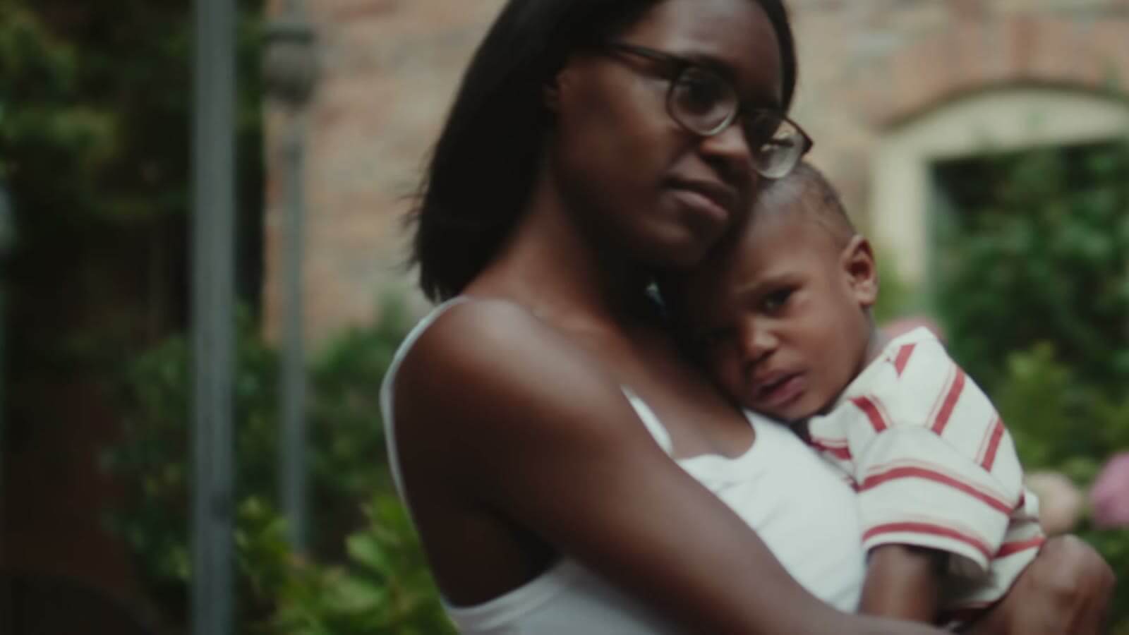 Where Hope Is Born - video poster A mother holding her young son close in the garden at Room At The Inn